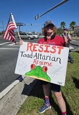 Woman holding Resist Totalitarian Regime sign at Indivisible North Pinellas Florida rally