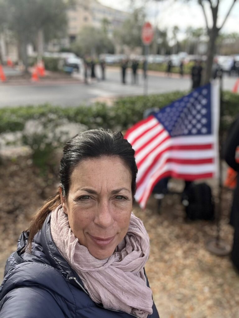 Woman with American flag at ICE recruitment protest, progressive grassroots action in Clearwater