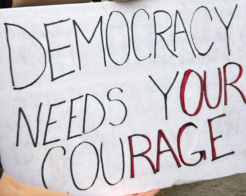Democracy needs your courage sing. WIth Our Rage in having red adding to the black pen uses on letters