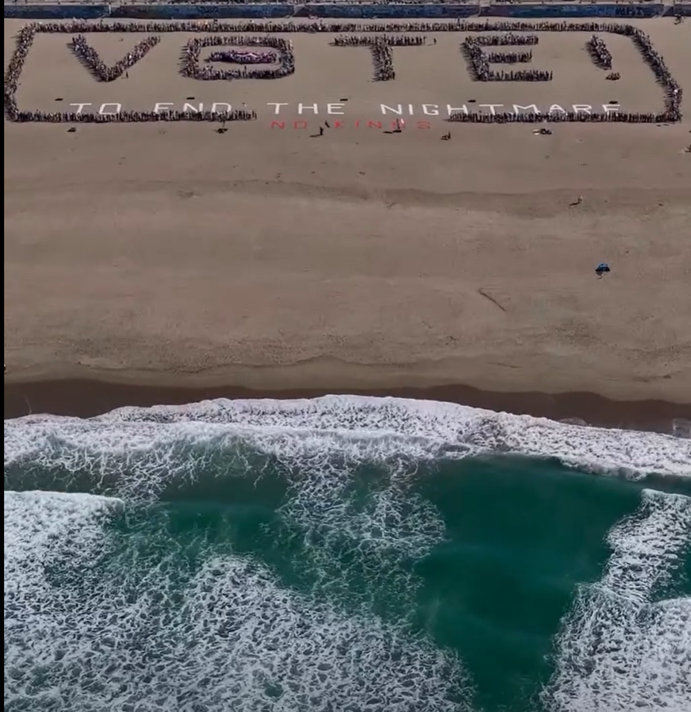 People on beach create a human sign Vote! To end the nightmare