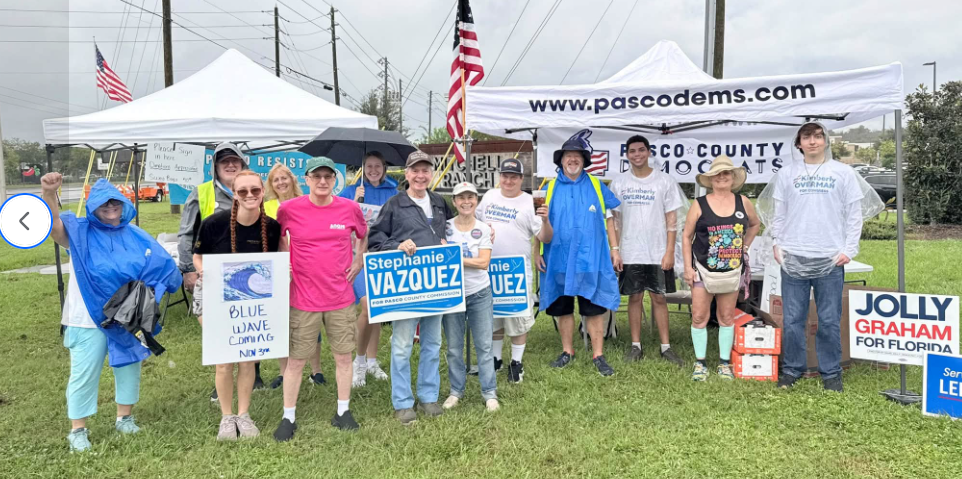 Pasco Dems standing in front of their tent on a rainy day 101726