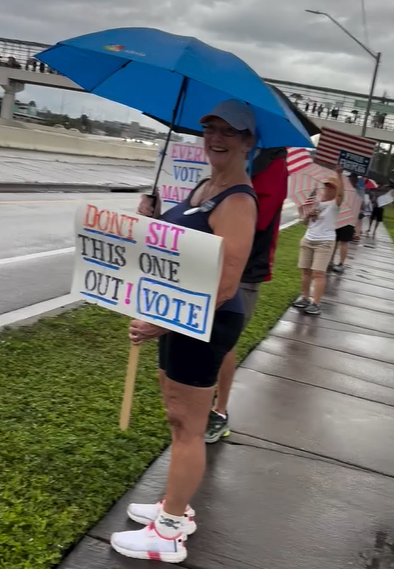 Lady in rain sign Don't sit this one out! Vote