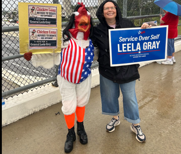 Operation Overpass lady with sing and person in chicken outfit. Service Over Self Leela Gray