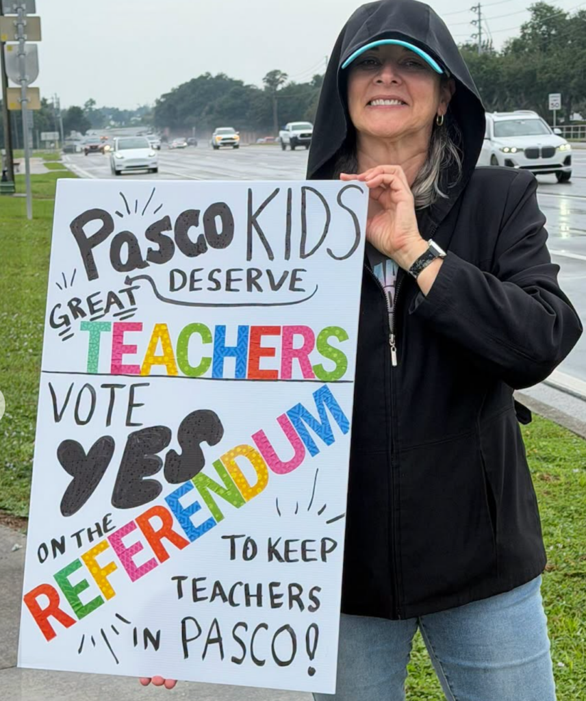 Lady with sign Vote YES on Referendum to keep teachers in Pasco