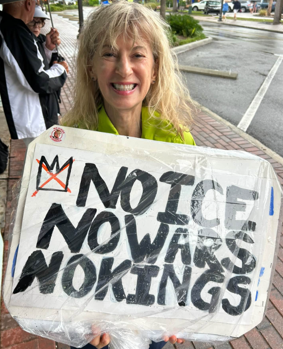 Lady with sign No ICE, No Wars, No Kings